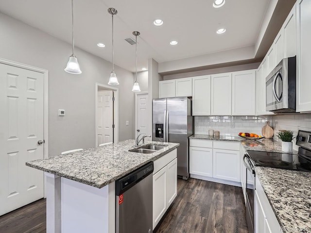 kitchen featuring stainless steel appliances, decorative light fixtures, a kitchen island with sink, white cabinets, and sink