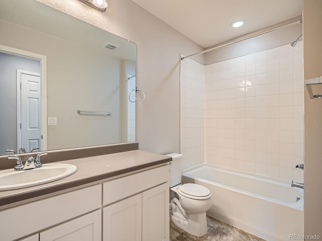 full bathroom featuring toilet, tiled shower / bath combo, and vanity