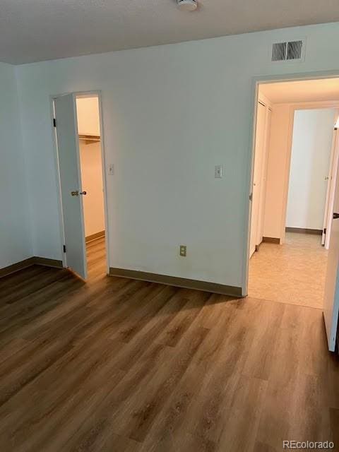 4400 S Quebec St Unit 102R, Denver, CO 80237 - spare room with wood finished floors, baseboards, and a smoke detector