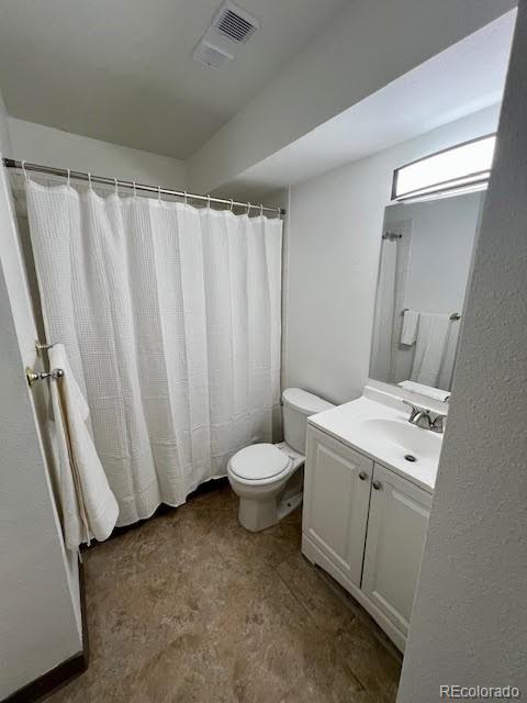 4400 S Quebec St Unit 102R, Denver, CO 80237 - bathroom featuring toilet, vanity, and a shower with shower curtain