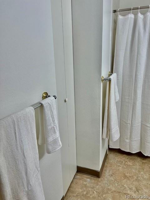 4400 S Quebec St Unit 102R, Denver, CO 80237 - bathroom with baseboards and a shower with curtain