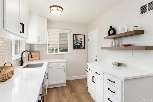 4520 S Delaware St, Englewood, CO 80110 - kitchen with a sink, baseboards, light wood-style flooring, backsplash, and white cabinetry