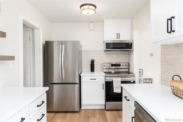 4520 S Delaware St, Englewood, CO 80110 - kitchen with appliances with stainless steel finishes, tasteful backsplash, light countertops, and white cabinets