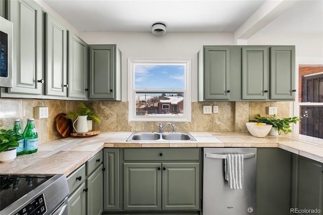 kitchen featuring sink, decorative backsplash, dishwasher, and green cabinets