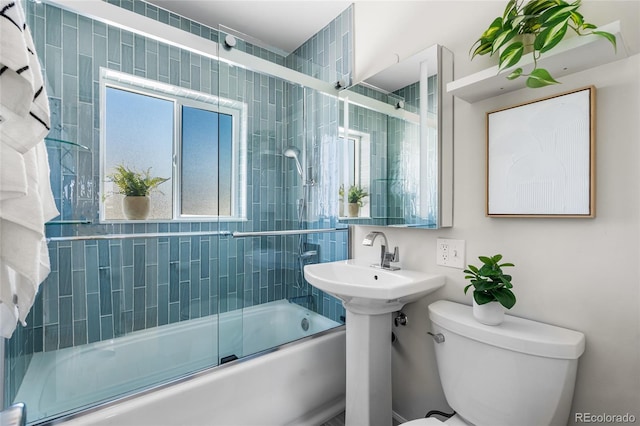 bathroom with bath / shower combo with glass door and toilet