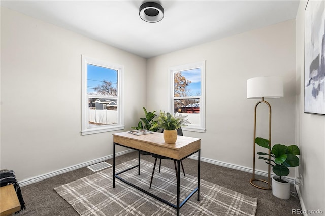 home office featuring a wealth of natural light and dark colored carpet