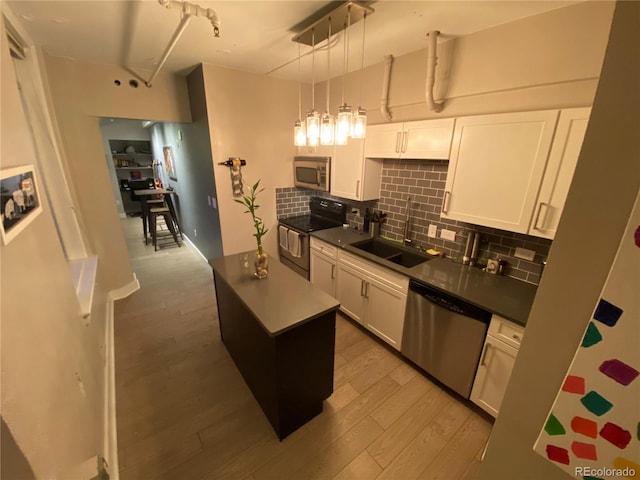 444 17th St Unit 508, Denver, CO 80202 - kitchen featuring appliances with stainless steel finishes, wood finished floors, tasteful backsplash, white cabinetry, and dark countertops