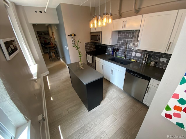 444 17th St Unit 508, Denver, CO 80202 - kitchen featuring appliances with stainless steel finishes, light wood-style flooring, backsplash, and white cabinets