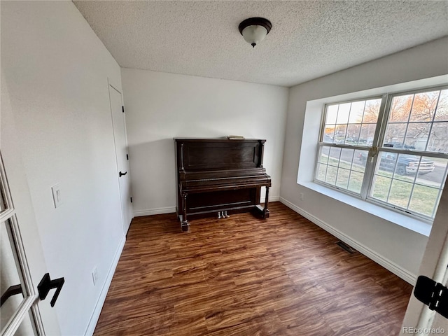 4036 S Himalaya Cir, Aurora, CO 80013 - living area featuring a textured ceiling, dark wood-type flooring, and baseboards