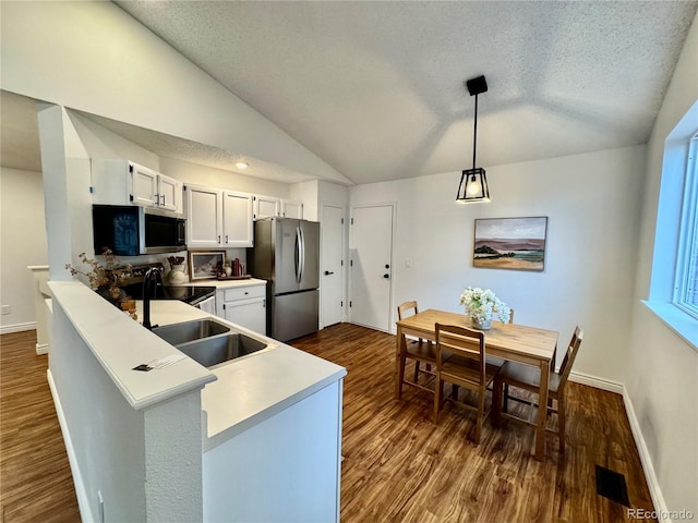 4036 S Himalaya Cir, Aurora, CO 80013 - kitchen with appliances with stainless steel finishes, lofted ceiling, dark wood-style flooring, a textured ceiling, and baseboards