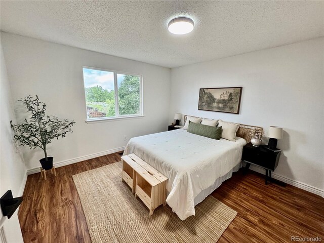 4036 S Himalaya Cir, Aurora, CO 80013 - bedroom featuring a textured ceiling, dark wood finished floors, and baseboards