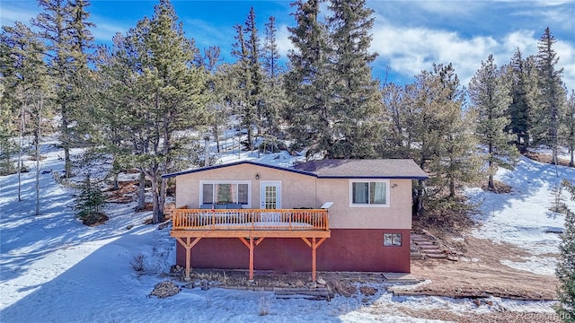 snow covered house featuring a deck