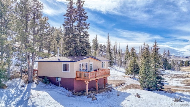 view of snow covered exterior with a wooden deck