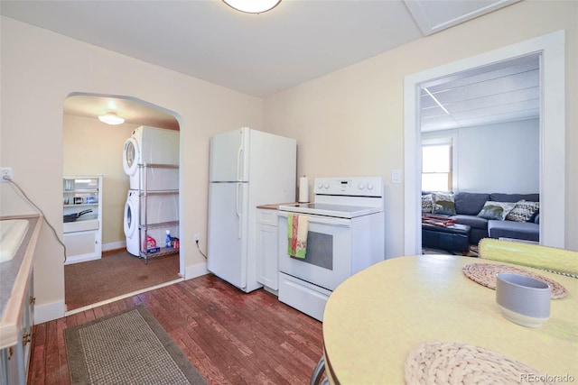 140 Eighth St, Fairplay, CO 80440 - kitchen with white appliances, stacked washer / dryer, dark wood-style floors, arched walkways, and light countertops