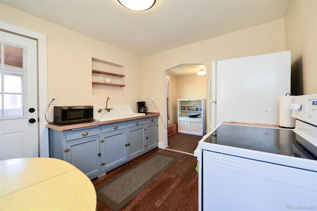 140 Eighth St, Fairplay, CO 80440 - kitchen featuring white appliances, arched walkways, dark wood finished floors, open shelves, and a sink