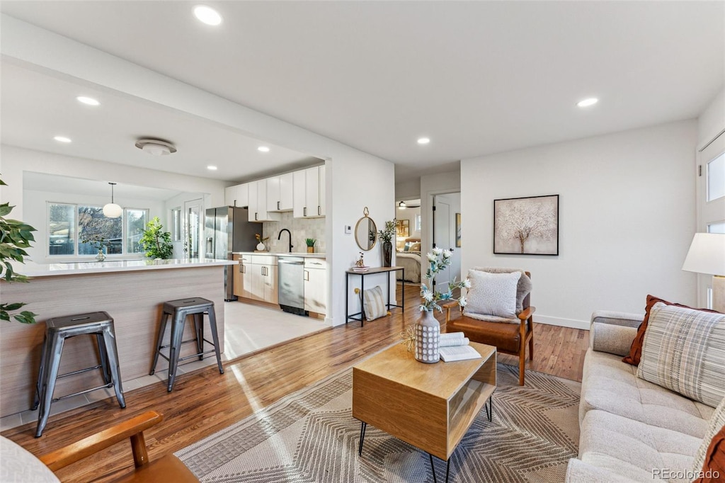 living room featuring sink and light hardwood / wood-style floors