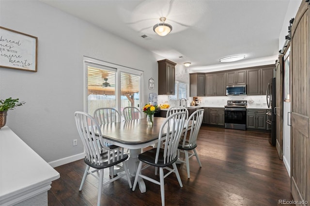 16086 E 97th Pl, Commerce City, CO 80022 - dining room featuring a barn door and dark wood finished floors