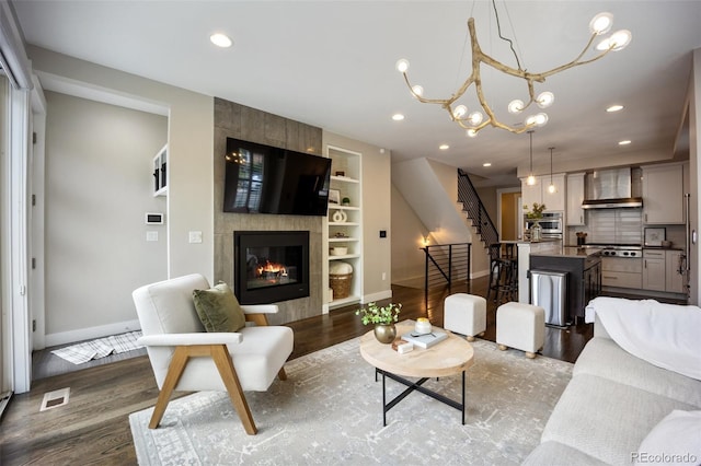 3690 W Byron Pl, Denver, CO 80211 - living area featuring dark wood-style flooring, stairs, built in features, recessed lighting, and a tiled fireplace