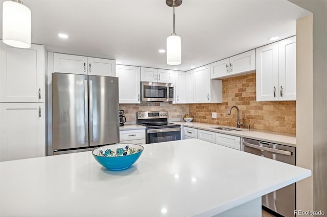 kitchen featuring a sink, white cabinets, light countertops, appliances with stainless steel finishes, and decorative backsplash