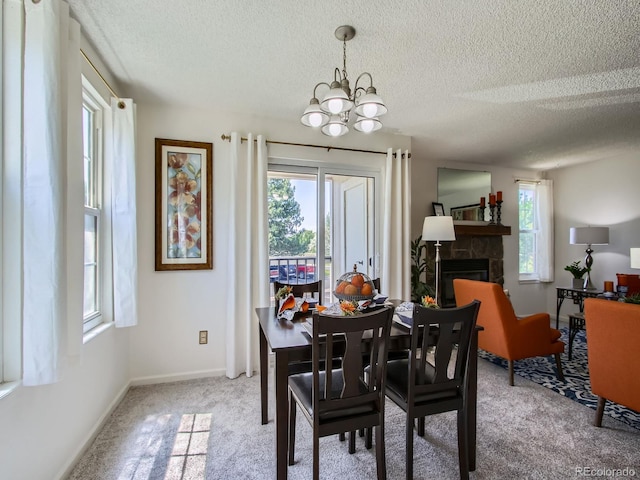 7700 N Depew St Unit 1518, Arvada, CO 80003 - carpeted dining area featuring a textured ceiling, healthy amount of natural light, a stone fireplace, and a chandelier