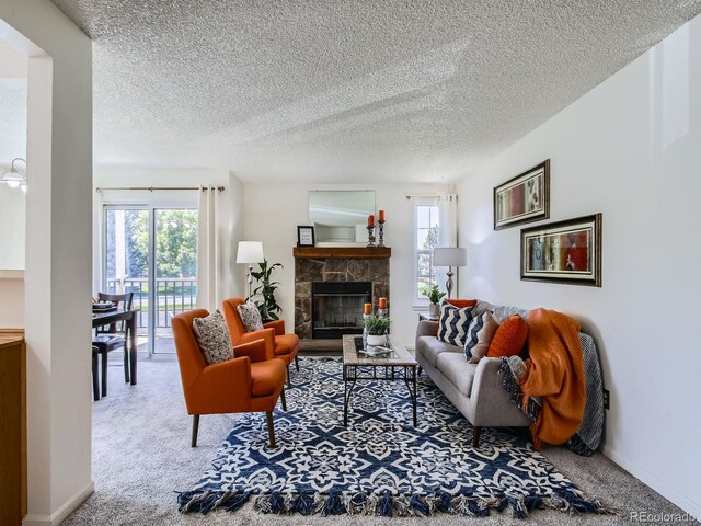 7700 N Depew St Unit 1518, Arvada, CO 80003 - carpeted living room featuring plenty of natural light, a stone fireplace, and a textured ceiling
