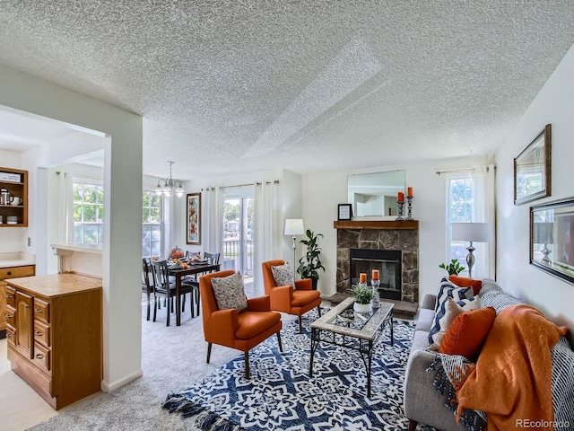 7700 N Depew St Unit 1518, Arvada, CO 80003 - living area featuring healthy amount of natural light, a fireplace, a textured ceiling, and a chandelier