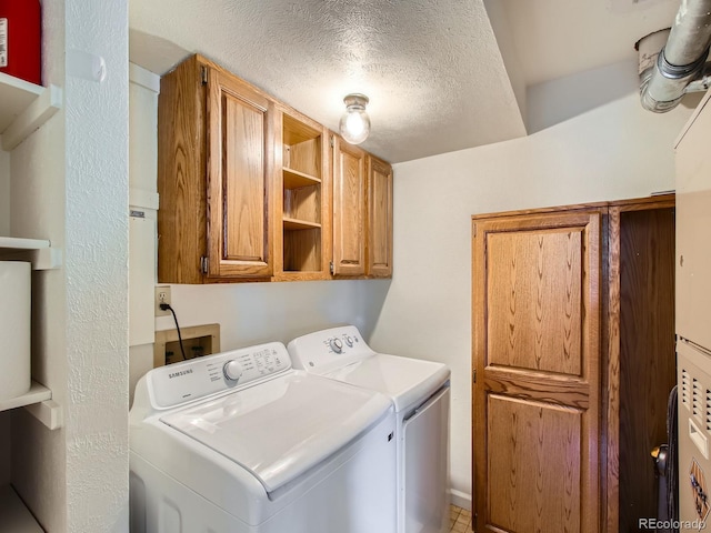 7700 N Depew St Unit 1518, Arvada, CO 80003 - laundry area with washing machine and dryer, cabinet space, and a textured ceiling