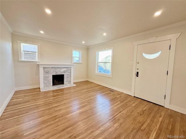 interior space featuring crown molding, a high end fireplace, and light wood-type flooring