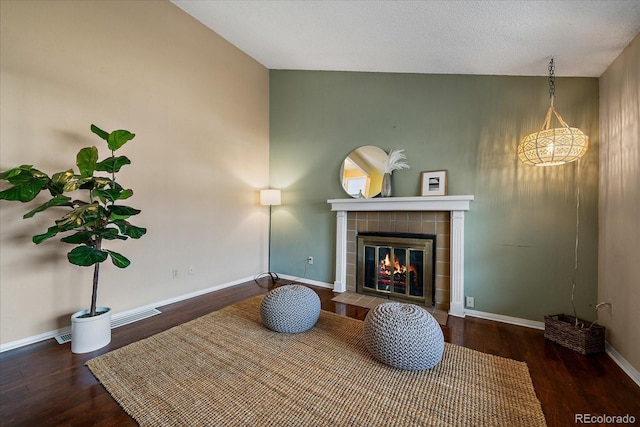 sitting room featuring dark wood-type flooring, a fireplace, and baseboards