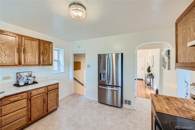 2854 Eliot St, Denver, CO 80211 - kitchen featuring arched walkways, brown cabinetry, visible vents, and stainless steel refrigerator with ice dispenser