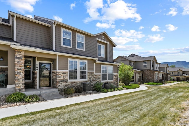 view of front of house with central AC unit and a front yard