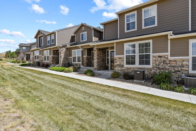 craftsman inspired home featuring central air condition unit and a front lawn