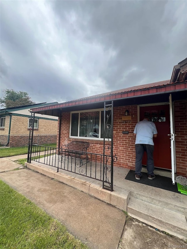 2655 Pontiac St, Denver, CO 80207 - view of front facade with brick siding and a porch
