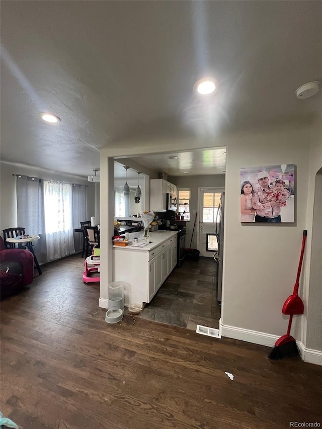 2655 Pontiac St, Denver, CO 80207 - kitchen featuring electric range oven, dark wood-style flooring, baseboards, white cabinets, and light countertops