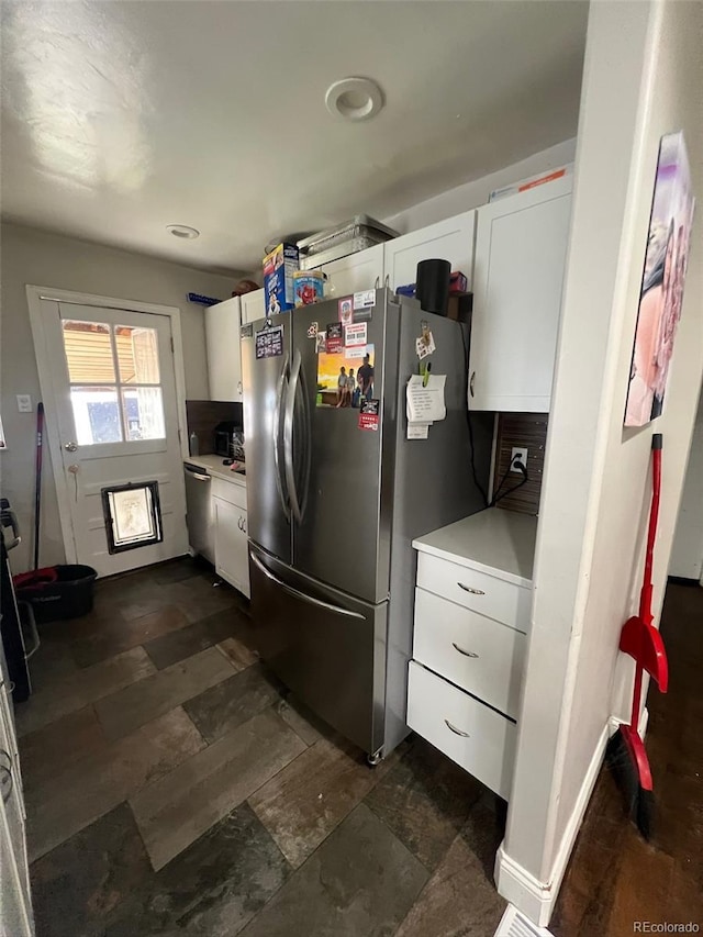 2655 Pontiac St, Denver, CO 80207 - kitchen featuring freestanding refrigerator, white cabinets, light countertops, and dark stone finish floors
