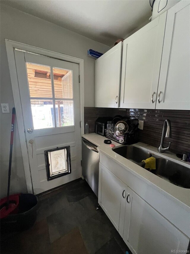 2655 Pontiac St, Denver, CO 80207 - kitchen featuring a sink, stainless steel dishwasher, backsplash, white cabinetry, and light countertops