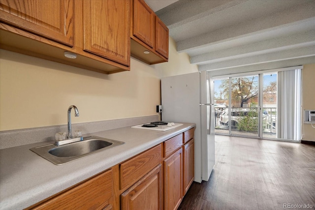 kitchen featuring a sink, light countertops, white appliances, dark wood finished floors, and brown cabinets