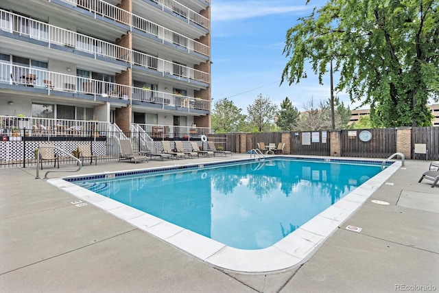 community pool featuring fence and a patio