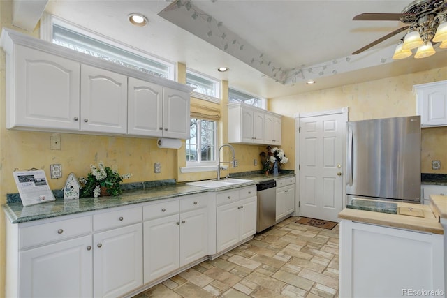 31 N Algonquian St, Aurora, CO 80018 - kitchen featuring appliances with stainless steel finishes, a sink, a ceiling fan, white cabinetry, and brick patterned flooring