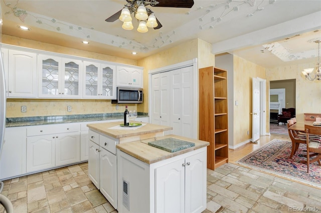 31 N Algonquian St, Aurora, CO 80018 - kitchen featuring stainless steel microwave, ceiling fan, a raised ceiling, white cabinets, and recessed lighting