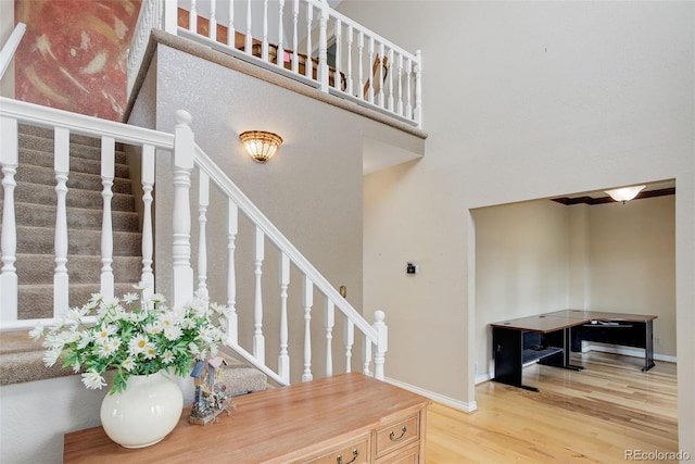 31 N Algonquian St, Aurora, CO 80018 - staircase with wood finished floors, baseboards, and a high ceiling
