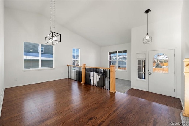 entrance foyer featuring vaulted ceiling and dark hardwood / wood-style floors