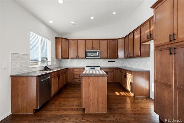 kitchen with sink, a kitchen island, dark hardwood / wood-style floors, and appliances with stainless steel finishes