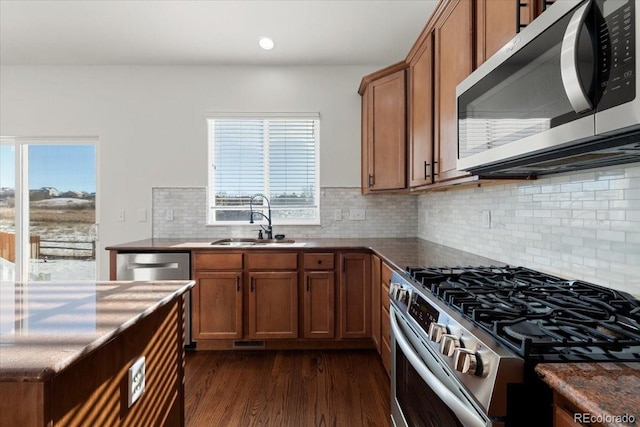 kitchen featuring dark hardwood / wood-style flooring, sink, stainless steel appliances, and tasteful backsplash