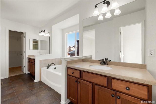 bathroom featuring vanity, a tub to relax in, and an inviting chandelier