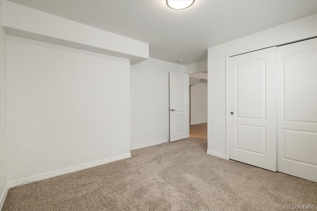 unfurnished bedroom featuring light carpet and a closet