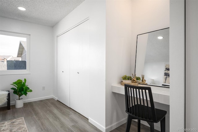 interior space featuring recessed lighting, wood finished floors, baseboards, and a textured ceiling