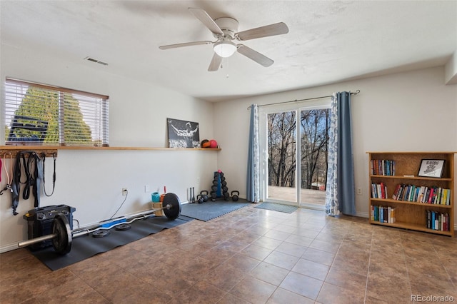 workout room with tile patterned floors, a ceiling fan, and visible vents