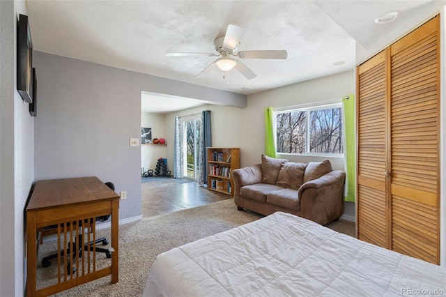 carpeted bedroom featuring a closet, baseboards, and ceiling fan