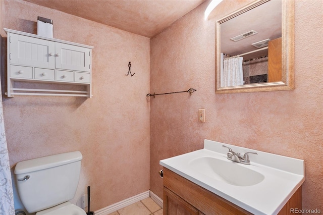 full bath featuring visible vents, toilet, tile patterned flooring, vanity, and a textured wall